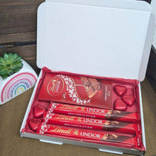 Load image into Gallery viewer, Lindt Lover Chocolate Letterbox Gift from The Happiness Box featuring premium Lindt chocolates in red tissue paper.
