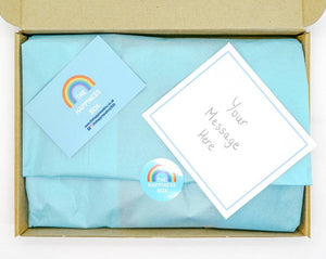 A colourful Children’s Letterbox Gift from The Happiness Box, filled with treats and activities, lined with tissue paper.